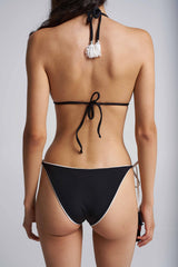 Black bikini with white trim on a plain background